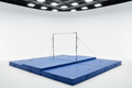 Full competition-style gymnastics high bar over a massive blue landing pit, professional studio lighting